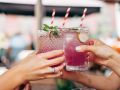 Frauen stoßen mit Cocktails an