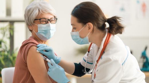 An elderly woman receiving a vaccination
