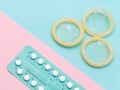 Pille und Kondom auf Pastellhintergrund