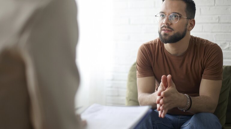Ein Mann nimmt an einer Therapiesitzung teil und schildert etwas aus seinem Leben