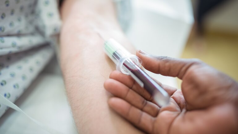 Arzt nimmt Patienten Blut ab