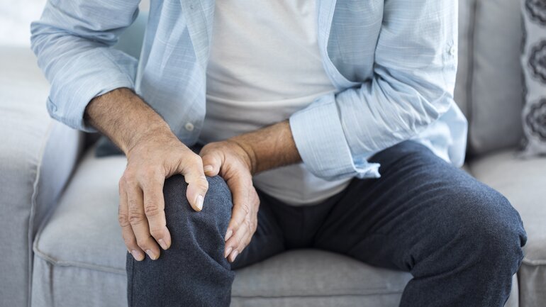 Mann mit schmerzendem Knie