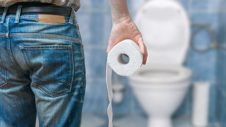 Mann mit Durchfall geht auf Klo