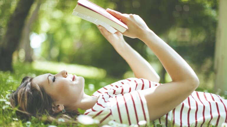 Frau beim Lesen im Park