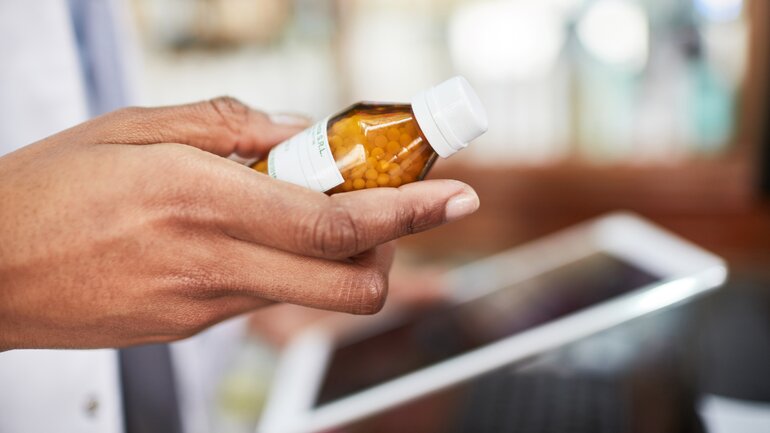 Apothekerin hält homöopathische Globuli in der Hand