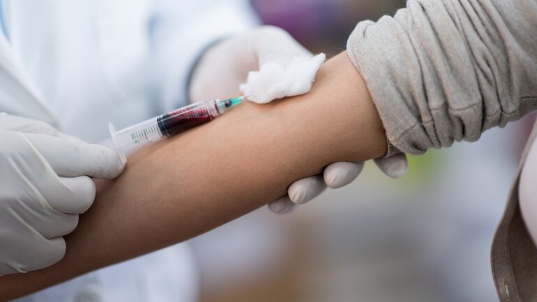 Arzt beim Blut abnehmen