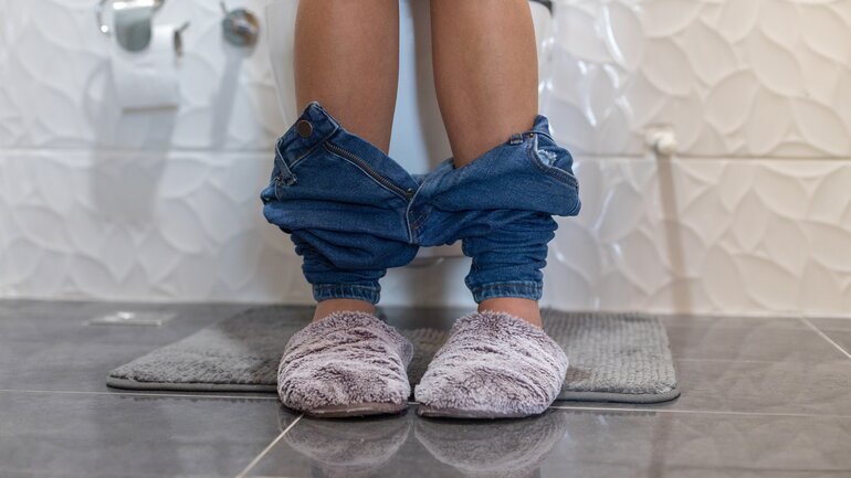 Frau auf Toilette