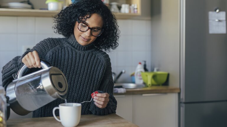 Hausmittel: Frau gießt eine Tasse Tee auf