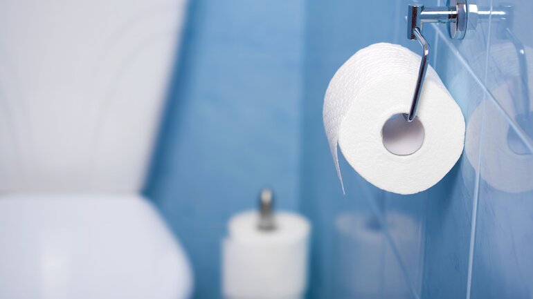 Toilettenpapier in blauem Bad