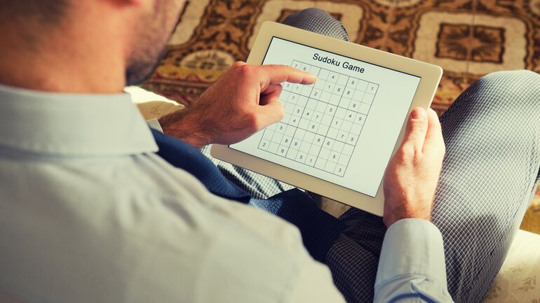 Mann löst Sudoku auf Tablet
