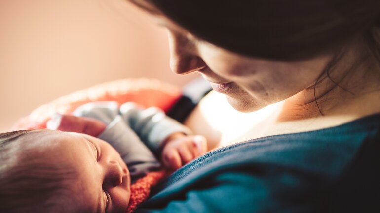 Mutter mit ihrem neugeborenen Baby im Wochenbett
